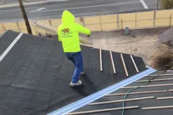 Worker on rooftop tar paper